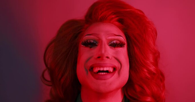 Drag queen smiling on camera with red light inside studio - Lgbtq concept 