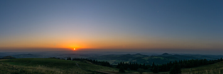 Naklejka na ściany i meble Panoramic view during sunset from Wasserkuppe, the highest point in Roehn Mountains under a clear sky, Germany