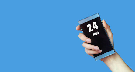 june 24. 24th day of the month, calendar date.Woman's hand holds mobile phone with blank screen on blue isolated background.Summer month, day of the year concept