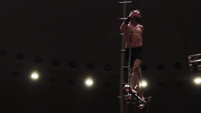 Training in empty circus - a man standing on the metal construction for the show in the air