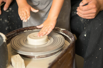 hands make a clay product out of clay on a circle