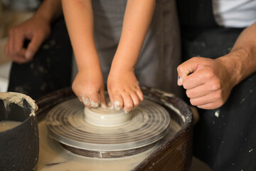 hands make a clay product out of clay on a circle