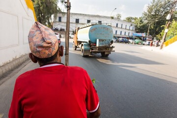 Rikshaw driver on a road wearing red shirt.