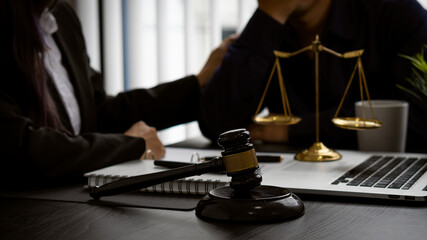 Lawyer Counsel provides encouraging advice to business people in the office with judge hammer and judge scale with laptop lawyer ideas and legal advisor.