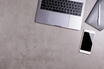 Cropped shot of minimalistic workspace. Tabletop of concrete textured desk with metallic grey...