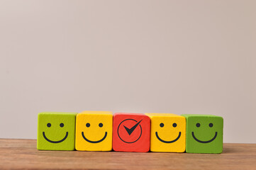 Colorful wooden blocks with emotion face. Customer evaluation and satisfaction concept.
