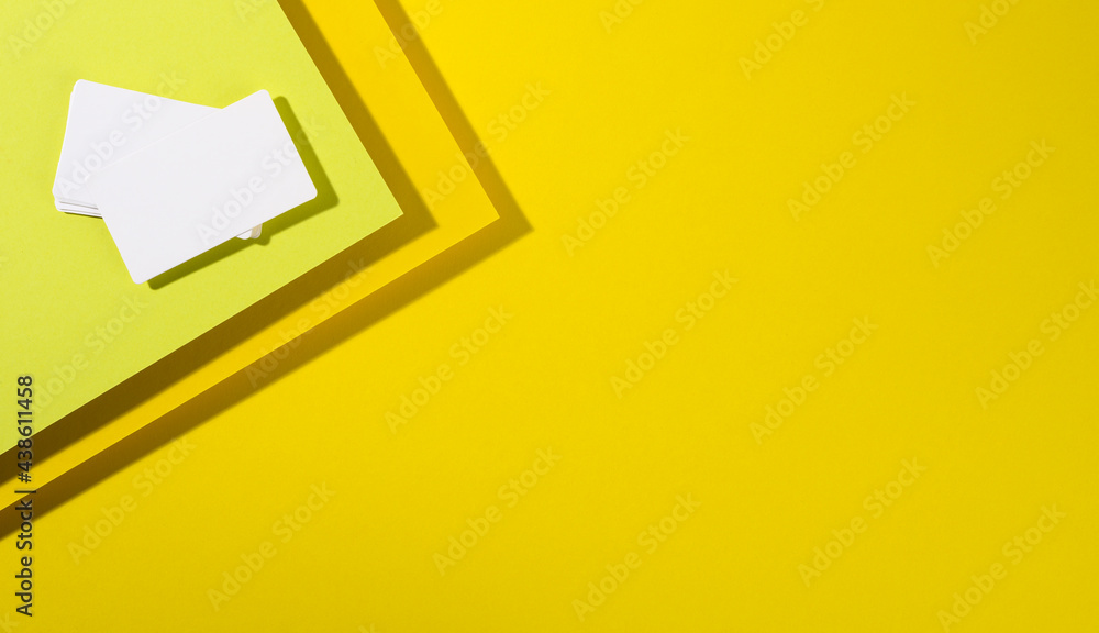 Poster blank white rectangular business card on creative yellow background from sheets of paper with shadow