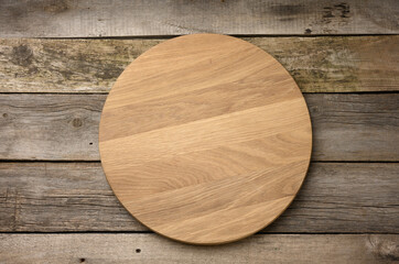 empty round wooden cutting kitchen board on wooden background, pizza board