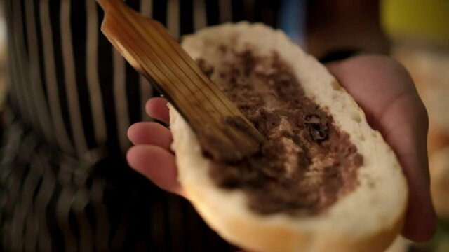 Male hands spreading refried beans on a slice of bread