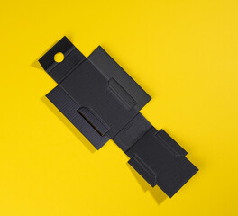 Obraz premium collapsible inner protective black box made of corrugated cardboard for packages with breakable goods on a yellow background