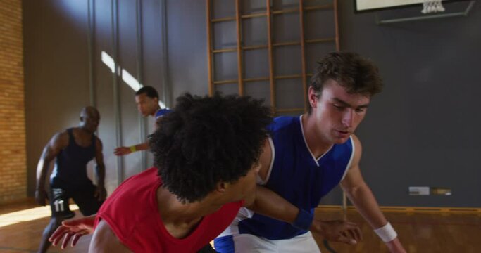Diverse male basketball team and coach practice dribbling ball
