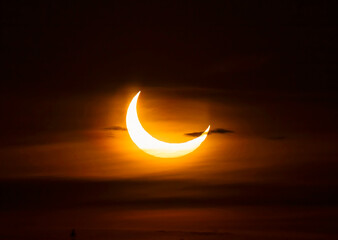 Fototapeta na wymiar Annular Solar Eclipse through the morning clouds - June 10, 2021, Rural Kanata, Ontario, Canada
