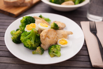 chicken breast with broccoli and quail eggs on plate for healthy dinner