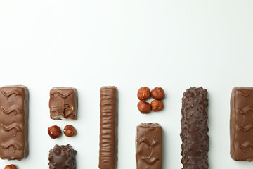 Different tasty candy bars on white background