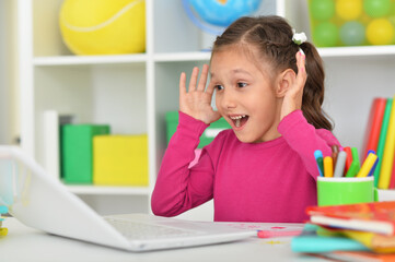 Porait of cute girl using laptop at home