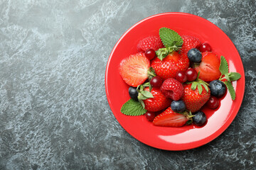 Plate with berry mix on black smokey background