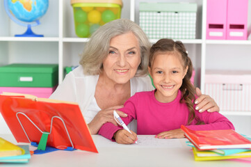 Fototapeta premium Cute little girl drawing with her grandmother