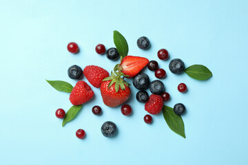 Delicious fresh berry mix on blue background