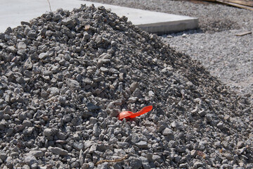Children's red spatula in a pile of rubble.