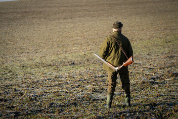 Scenic view of hunter waiting for a prey. Gamekeeper walks over field.