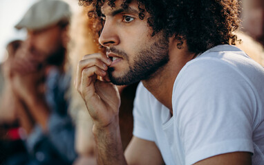 Man looking worried while watching a match at stadium