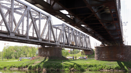 Railway bridge over the river, bottom view in the summer.