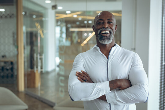 Portrait of african american businessman smiling, looking at camera with arms crossed