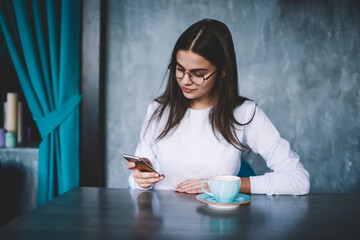 Thoughtful woman text messaging on smartphone