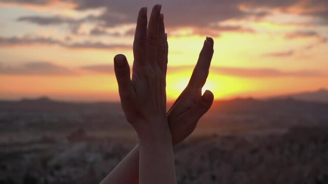 Close-up view 4k stock video footage of romantic woman making two hands like flying birds on bright sunny sunset or sunrise sky mountains background. Hands moving in gestures as wings of doves, gulls 