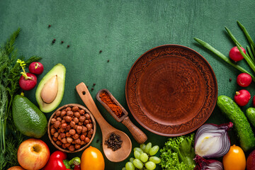 Frame of assorted fresh vegetables and fruits on green table. Food frame on green background with copy space.