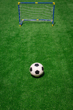 Football, Soccer Ball And Small Football Goal On Green Grass