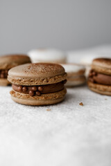 Macaroons on light bright background, colorful french cookies macaroons. Macaroons. Vanilla and chocolate dessert. Healthy no sugar vegetarian. Gift for 8 March - International Women's Day
