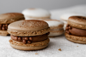 Macaroons on light bright background, colorful french cookies macaroons. Macaroons. Vanilla and chocolate dessert. Healthy no sugar vegetarian. Gift for 8 March - International Women's Day