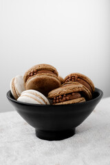 Macaroons on light bright background, colorful french cookies macaroons. Macaroons. Vanilla and chocolate dessert. Healthy no sugar vegetarian. Gift for 8 March - International Women's Day