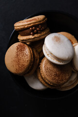 Macaroons on dark background, colorful french cookies macaroons. Macaroons. Vanilla and chocolate dessert. Healthy no sugar vegetarian. Gift for 8 March - International Women's Day