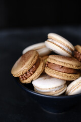 Macaroons on dark background, colorful french cookies macaroons. Macaroons. Vanilla and chocolate dessert. Healthy no sugar vegetarian. Gift for 8 March - International Women's Day