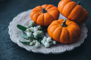 Festive composition. Miniature decorative pumpkins on a stone table top.