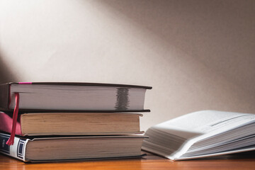 A stack of books. There's an open book next to it.