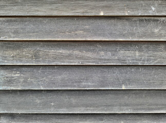 Grayed cedar clapboard siding worn by sunlight.
