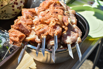 juicy shish barbecue from fresh meat on skewers for cooking on grill. Departure for nature, picnic season. prepared appetizer for frying over fire. Raw meat is strung on BBQ. shashlik is ready to cook