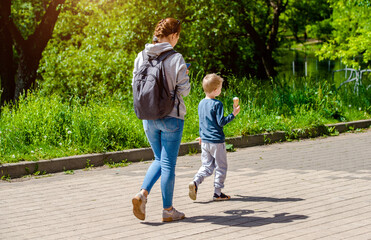 Obraz premium Mother and son walking in the summer Park 