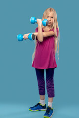 Long haired caucasian girl doing exercises with dumbbells