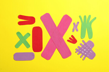 Obraz premium Different kinesio tape pieces on yellow background, flat lay