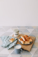 breakfast with puff buns and a glass of milk. freshly baked homemade pastry on kitchen table. 
