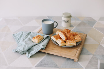 freshly baked homemade pastry on kitchen table. breakfast with puff buns and a glass of milk
