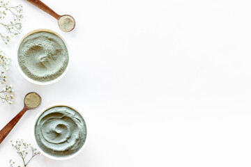 Cosmetic clay powder and mask in bowls, top view