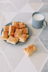 freshly baked homemade pastry on kitchen table. breakfast with puff buns and a glass of milk