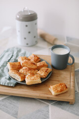 freshly baked homemade pastry on kitchen table. breakfast with puff buns and a glass of milk