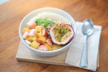 Bowl of healthy fresh fruit salad on wooden background. Fresh fruit salad with different ingredients on linen napkin. Healthy diet. Top view