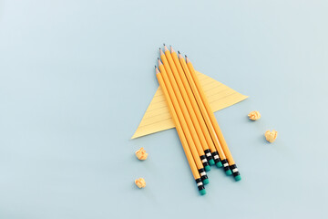 Back to school or education concept. rocket made from pencils over blue background